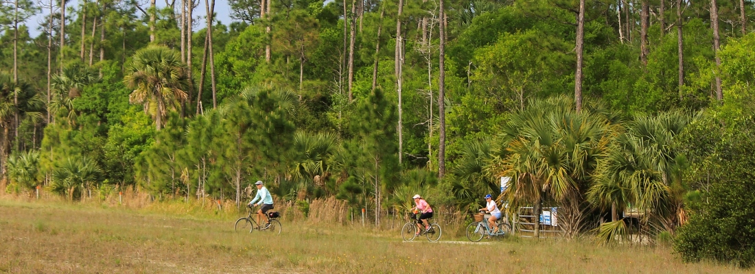 Picture of bicyclers leaving Riverbend Park and entering a Jeaga Wildway Multiuse Connector Trail