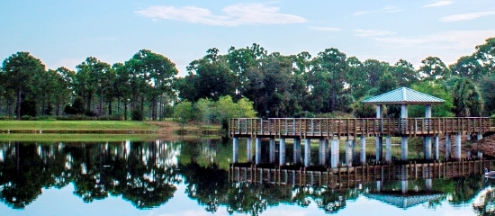Picture of a covered fishing pier in the foreground and North Jupiter Flatwoods Natural Area in the background