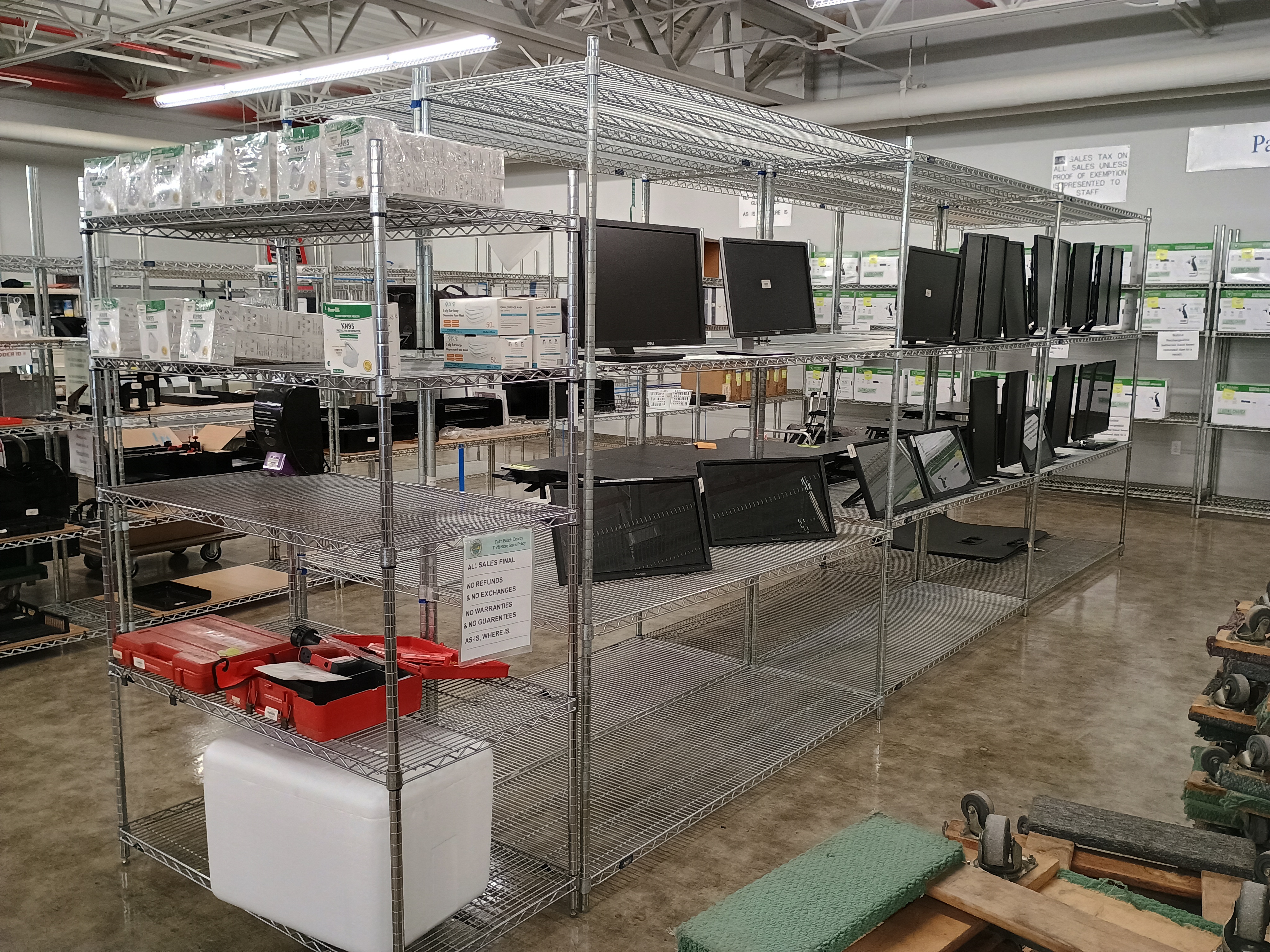 Metal wire racks with various merchandise, computer monitors and n95 face masks.jpg