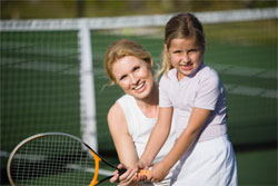 child with tennis instructor