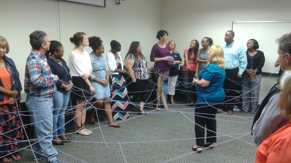 Participants holding string showing the connections between everyone